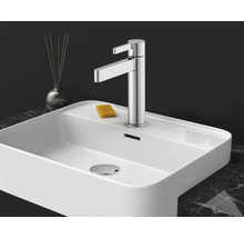Moderne Einhebel-Waschtischarmatur in Chrom auf einem weißen Keramik-Waschbecken mit Seife auf einer Marmoroberfläche.