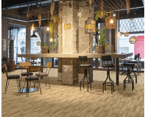 Industrie-Restaurant mit hellem Boden in Holzoptik, Betonsäulen, Barhockern aus Metall und hängenden Leuchten.