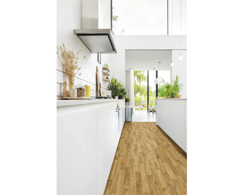 Helle, moderne Küche mit weißen Schränken und Laminatboden in Holzoptik. Inklusive Dunstabzugshaube aus Edelstahl und Blick in den Garten.