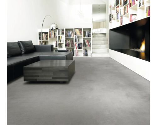 Modernes Wohnzimmer mit grauem Bodenbelag in Betonoptik, schwarzem Ledersofa, dunklem Couchtisch und minimalistischem Kamin.