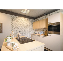 Moderne, helle Küche mit Kücheninsel inklusive schwarzem Kochfeld, hellen Holz-Oberschränken, weißen Unterschränken und floraler Tapete.