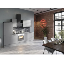 Moderne graue Küchenzeile im Loft-Stil mit Elektrogeräten vor einer Ziegelwand mit Neonschild und einem Esstisch im Vordergrund.
