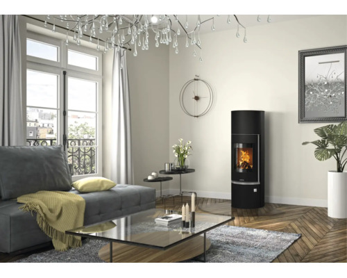 Modernes helles Wohnzimmer mit schwarzem Kaminofen, grauem Sofa, Glastisch und Fischgrätparkett. Große Fenster und dekorativer Kronleuchter.