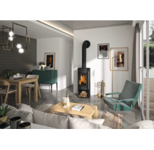 Modernes Wohnzimmer mit schwarzem Kaminofen mit brennendem Feuer, Holztisch, türkisem Sessel und hellen Wänden.