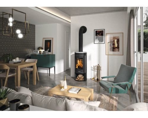 Moderner schwarzer Kaminofen mit brennendem Feuer im stilvoll eingerichteten Wohnzimmer mit Sessel, Couchtisch und Essbereich.