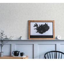 Ein gerahmtes Wandbild der Island-Karte auf einem Regal in einem minimalistischen Raum mit Wandpaneelen, einer Uhr und einer Teekanne.