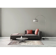 Modernes Wohnzimmer mit dunklem Stoffsofa, roten Kissen, rundem Marmor-Couchtisch, gemustertem Teppich und silberner Bogenstehleuchte.