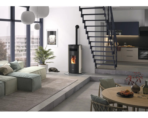 Moderner Pelletofen mit Glasscheibe und sichtbarem Feuer in einem hellen, minimalistischen Wohnzimmer mit Treppe und großen Fenstern.