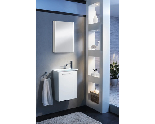 Modernes, helles Badezimmer mit weißem Waschtischunterschrank, Waschbecken und Spiegelschrank mit vertikaler LED-Beleuchtung vor grauer Wand.