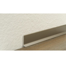 Kunststoff-Sockelleiste an einer strukturierten Wand und einem Boden mit Holzmaserung.