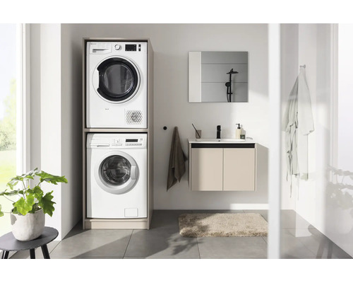 Modernes Badezimmer mit Waschmaschinenumbau für Waschmaschine und Trockner übereinander, Waschbeckenunterschrank und Spiegel.