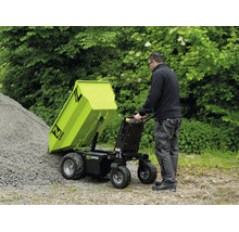 Ein Mann entleert einen Zipper Minidumper mit Kippvorrichtung auf einen Schotterhaufen im Garten. Funktionale, helle Außenanlage. Zipper Logo.