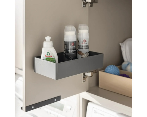 An einer Schranktür montierte graue Aufbewahrungsbox mit Reinigungsmitteln, ideal für Ordnung im Hausarbeitsraum.