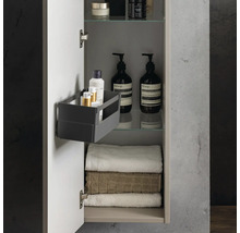 Geöffneter Badezimmerschrank mit Handtüchern, Kosmetikflaschen auf Glasböden und einer Ordnungsbox an der Türinnenseite.