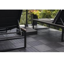 Anthrazitfarbene WPC-Terrassenfliesen mit Klicksystem auf einer Terrasse mit Gartenliegen und Sonnenschirmständer verlegt.