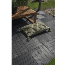 Rechteckiges Kissen mit getuftetem Rautenmuster und Quasten auf einer Terrasse mit Klickfliesen und Holztisch.