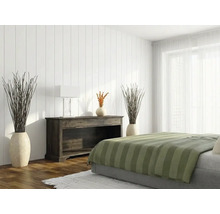 Helles Schlafzimmer mit weißen vertikalen Wandpaneelen, einem dunklen Sideboard aus Holz und einem Bett mit grün gestreifter Decke.