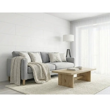 Helles Wohnzimmer mit grauem Sofa, Holzcouchtisch, weißen Wandpaneelen und Strickdecke im skandinavischen Stil.