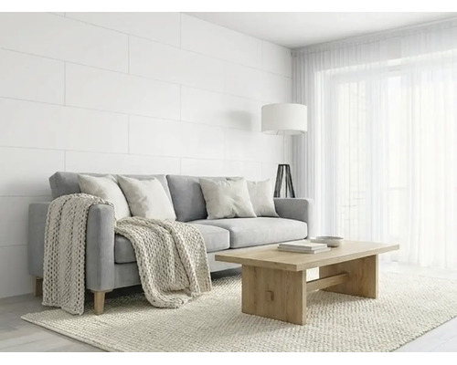Helles Wohnzimmer mit grauem Sofa, Holzcouchtisch, weißen Wandpaneelen und Strickdecke im skandinavischen Stil.