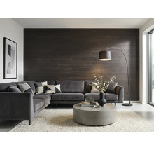 Modernes Wohnzimmer mit dunkler Wandverkleidung in Holzoptik, grauem Ecksofa aus Samt, rundem Couchtisch aus Beton und einer Bogenlampe.