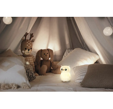Leuchtendes Nachtlicht in Eulenform in einem Kinderzelt mit Stofftieren und Kissen.