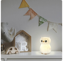 Eulenförmiges LED-Nachtlicht leuchtend in einem Kinderzimmer mit Holzspielzeug und Stoffwimpeln.