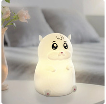 Leuchtendes LED-Nachtlicht in Hamsterform auf einem weißen Nachttisch in einem Schlafzimmer.