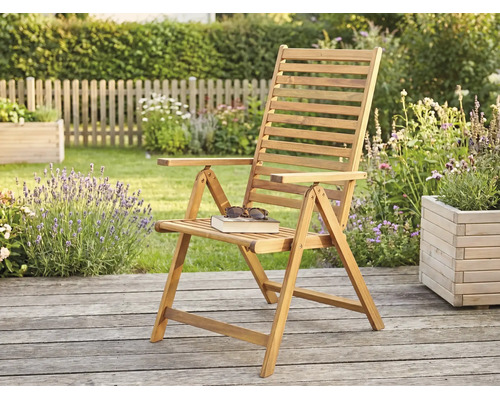 Holz-Klappsessel für den Garten auf einer Holzterrasse in einer hellen Gartenumgebung mit Pflanzen und Holzzaun.