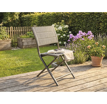 Klappbarer Gartenstuhl mit Metallgestell und Textilbespannung auf einer Holzterrasse im sonnigen Garten mit Blumen im Hintergrund.
