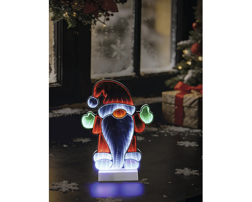 LED-Weihnachtswichtel mit Infinity-Spiegeleffekt auf einem Tisch vor einem winterlichen Fenster mit Weihnachtsbaum und Geschenk.