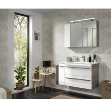 Modernes Badezimmer mit Waschtischunterschrank in Weiß und Holzoptik, Waschbecken und dreitürigem Spiegelschrank mit LED-Beleuchtung.
