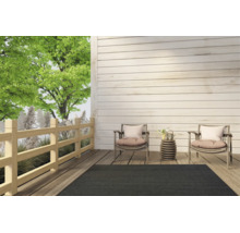 Dunkelgrauer Outdoor-Teppich auf einer modernen Holzterrasse mit zwei Sesseln und einem kleinen Beistelltisch.