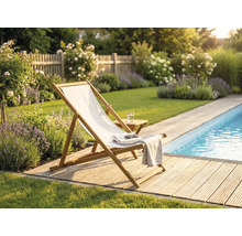 Sonnenstuhl aus Holz mit weißem Stoff auf einer Holzterrasse an einem Pool in einem Garten mit Lavendel und Rosen.