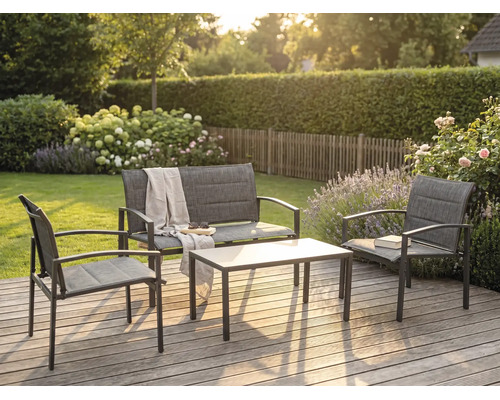 Modernes Garten-Lounge-Set aus Metall und Textilgewebe auf einer Holzterrasse, bestehend aus Bank, zwei Sesseln und Tisch im sonnigen Garten.