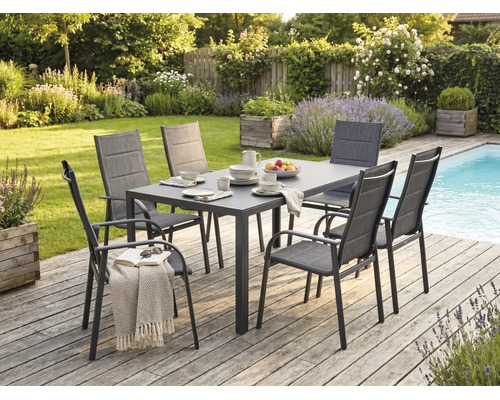 Moderne Garten-Essgruppe mit einem rechteckigen Tisch und sechs Stühlen auf einer Holzterrasse neben einem Pool im Garten.