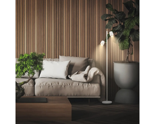 Moderne Wohnzimmerszene mit einer zweiflammigen Stehleuchte neben einem Sofa vor einer Wand mit Holzlamellen und einer großen Zimmerpflanze.