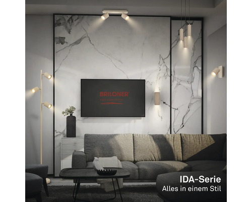 Modernes Wohnzimmer mit Lampen der Briloner IDA-Serie: Stehleuchte, Deckenstrahler, Pendelleuchte und Wandleuchten vor einer Wand in Marmoroptik.