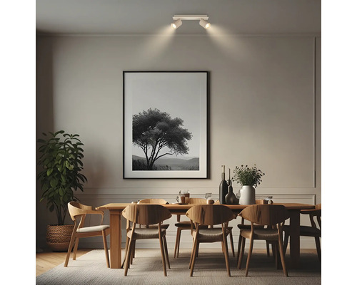 Zweiflammiger Deckenstrahler über einem Holzesstisch in einem modern eingerichteten Esszimmer mit Wandbild und Zimmerpflanze.