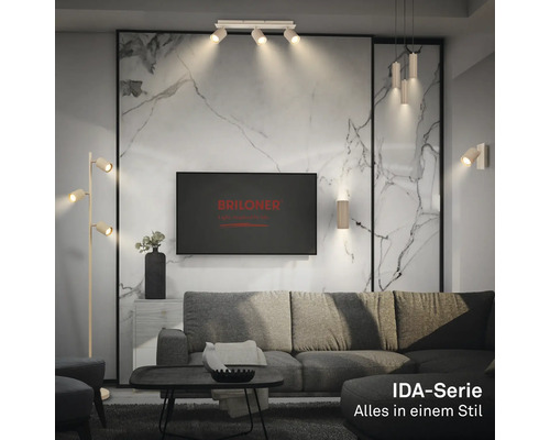 Modernes Wohnzimmer mit Leuchten der IDA-Serie, grauem Sofa, Wand in Marmoroptik und Briloner Logo auf dem Fernseher.