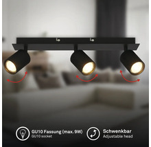 Schwarzer, dreiflammiger Deckenstrahler mit schwenkbaren Köpfen und GU10 Fassungen für maximal 9 Watt, in einem modernen Wohnraum.