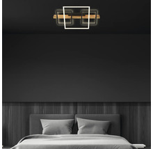 LED-Deckenleuchte mit drei quadratischen Elementen und Holzleiste in einem modern eingerichteten Schlafzimmer mit dunkler Wandgestaltung.