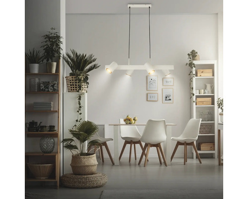 Moderne 4-flammige Pendelleuchte in Weiß über einem skandinavischen Essbereich mit hellem Tisch, Stühlen und vielen Zimmerpflanzen.