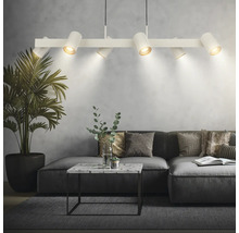 Moderne weiße Pendelleuchte mit sechs verstellbaren Strahlern über einem grauen Sofa im Wohnzimmer mit Marmortisch und Zimmerpflanze.