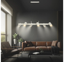 Moderne sechsflammige Pendelleuchte aus Metall mit verstellbaren Spots über einem Sofa im Wohnzimmer.