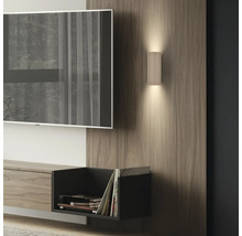 Moderne zylindrische Wandleuchte mit Rillen auf Holzpaneel im Wohnzimmer, Up-and-Down-Beleuchtung neben Fernseher.