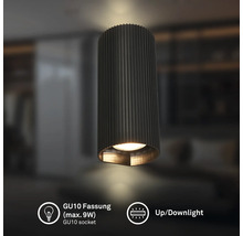 Zylindrische Up- und Downlight-Leuchte mit geriffelter Oberfläche, GU10 Fassung maximal 9 Watt, in einem modern eingerichteten Raum.