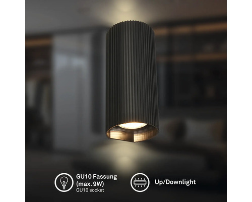 Zylindrische Up- und Downlight-Leuchte mit geriffelter Oberfläche, GU10 Fassung maximal 9 Watt, in einem modern eingerichteten Raum.