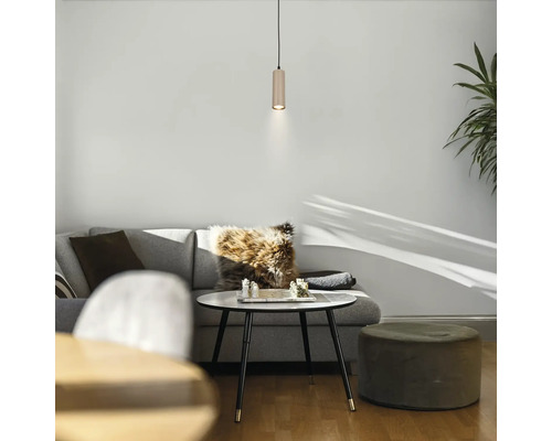 Hell eingerichtetes Wohnzimmer mit grauem Sofa, weißem Couchtisch, Schachspiel, zylindrischer Pendelleuchte und Samthocker.