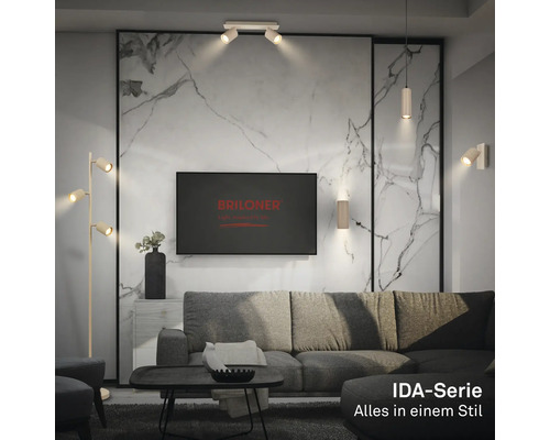 Modernes Wohnzimmer mit Deckenstrahlern, Wandlampen und Stehlampe der Briloner IDA-Serie sowie Briloner Logo auf dem Bildschirm.