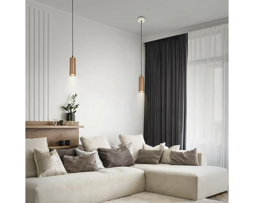 Modernes Wohnzimmer mit großem Ecksofa und zwei zylindrischen Pendelleuchten aus Metall über dem Couchbereich.